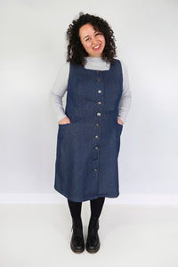 Woman wearing the Dulcie Pinafore sewing pattern from Jennifer Lauren Handmade on The Fold Line. A pinafore dress pattern made in denim, corduroy, wool, suitings, tweeds and mammoth flannel fabrics, featuring a button-front, square neckline, semi-fitted A