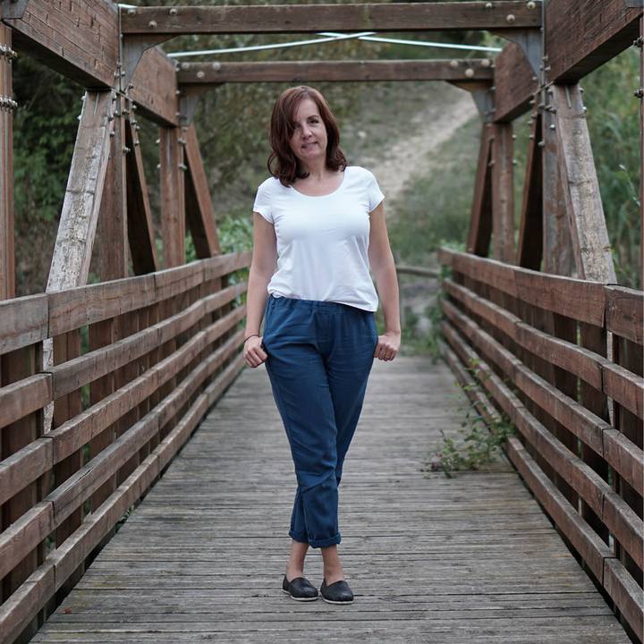 Woman wearing the Easy Pants sewing pattern from Wardrobe by Me on The Fold Line. A trouser pattern made in non-stretch cotton, linen, canvas or denim fabrics, featuring a relaxed fit, elastic waist, side pockets, back welt pockets, slim legs and cuffed h