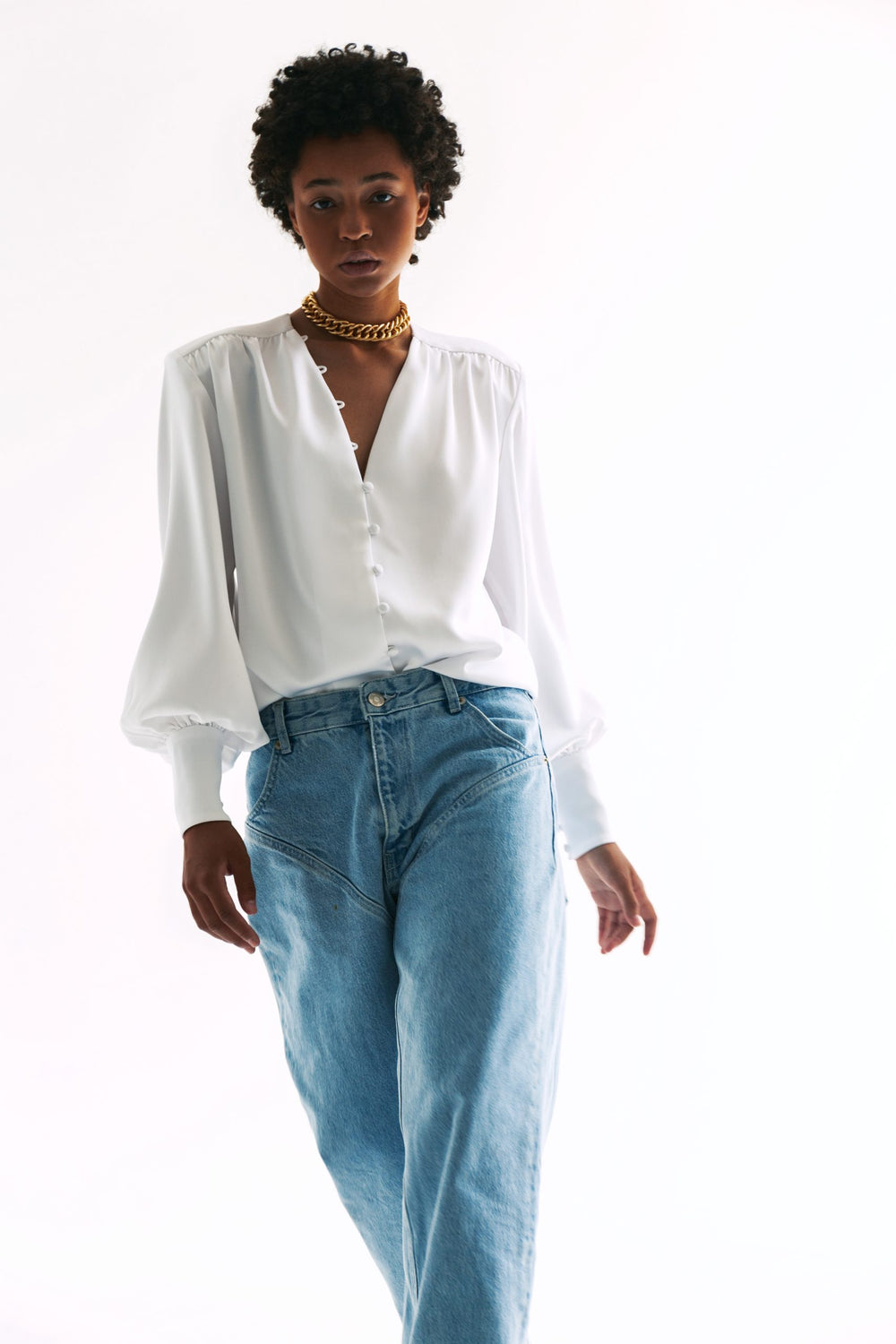 Woman wearing the Edwige Blouse sewing pattern from Vikisews on The Fold Line. A blouse pattern made in silk, viscose, crepe, thin atlas or chiffon fabrics, featuring a loose fit, straight silhouette, front yokes with gathers, slight dropped shoulder, dee