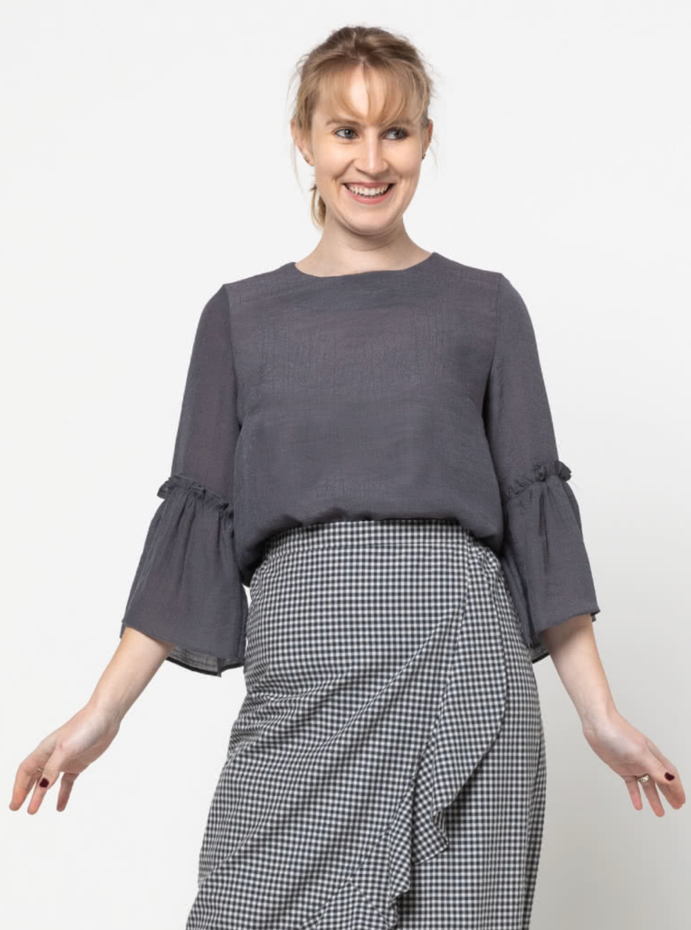 Women wearing the Effie Woven Top sewing pattern from Style Arc on The Fold Line. A top pattern made in rayon, silk or crepe fabrics, featuring a round neck, bust darts, 3/4 length sleeves with wide frill, back button-and-loop closure, and mid-hip length.