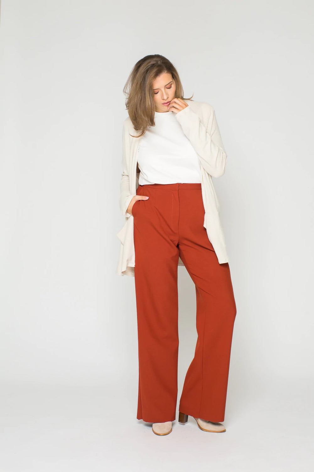 Woman wearing the Elina Trousers sewing pattern from Bara Studio on The Fold Line. A trouser pattern made in wool, cotton or blends fabrics, featuring front and back darts, slash pockets and wide straight legs.