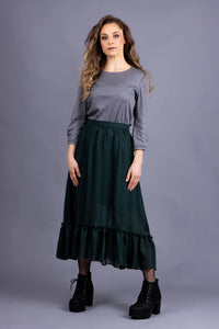 Woman wearing the Ella Skirt sewing pattern from Forget-me-not Patterns on The Fold Line. A gathered skirt pattern made in cotton, viscose/rayon, silk, wool, or linen fabric, featuring a subtle high-low hem finished with a gathered tier, A-line silhouette