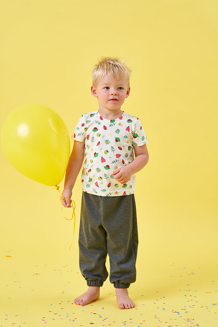 Child wearing the Baby/Child Elm T-shirt sewing pattern from Poppy & Jazz on The Fold Line. A T-shirt pattern made in cotton jersey or viscose jersey fabrics, featuring short sleeves and a round neck with optional press stud opening.