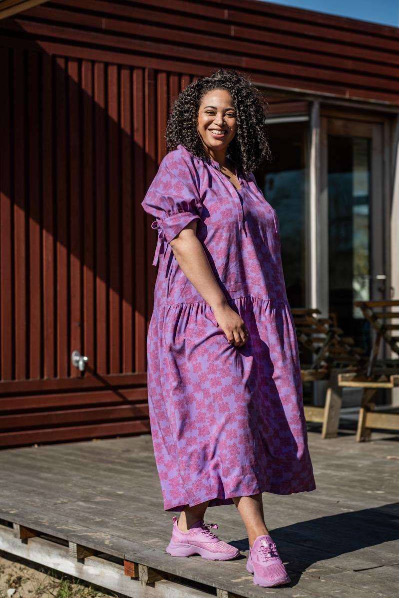 Woman wearing the Elora Dress sewing pattern from Fibre Mood on The Fold Line. A dress and top pattern made in voile, poplin, broderie anglaise, chambray, silk (satin), lyocell, crepe or double gauze fabrics, featuring a soft gathered V-neck, balloon ragl