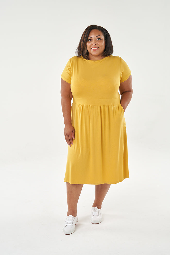 Woman wearing the Esma Dress sewing pattern from Sew Over It on The Fold Line. A dress pattern made in viscose or bamboo jersey, French terry or lightweight cotton jersey fabrics, featuring a rounded neckline, short sleeves, wide waistband, gathered skirt