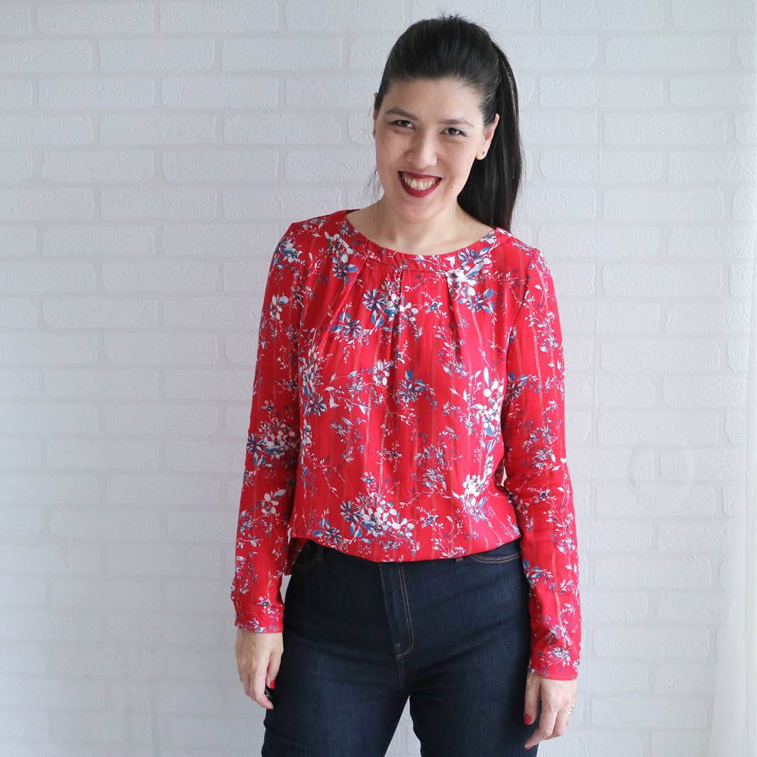 Woman wearing the Esther Blouse sewing pattern from Wardrobe by Me on The Fold Line. A blouse pattern made in cotton voile, viscose or silk fabrics, featuring a round neck with front neckline pleats, button and slit back closure, full length sleeves with 