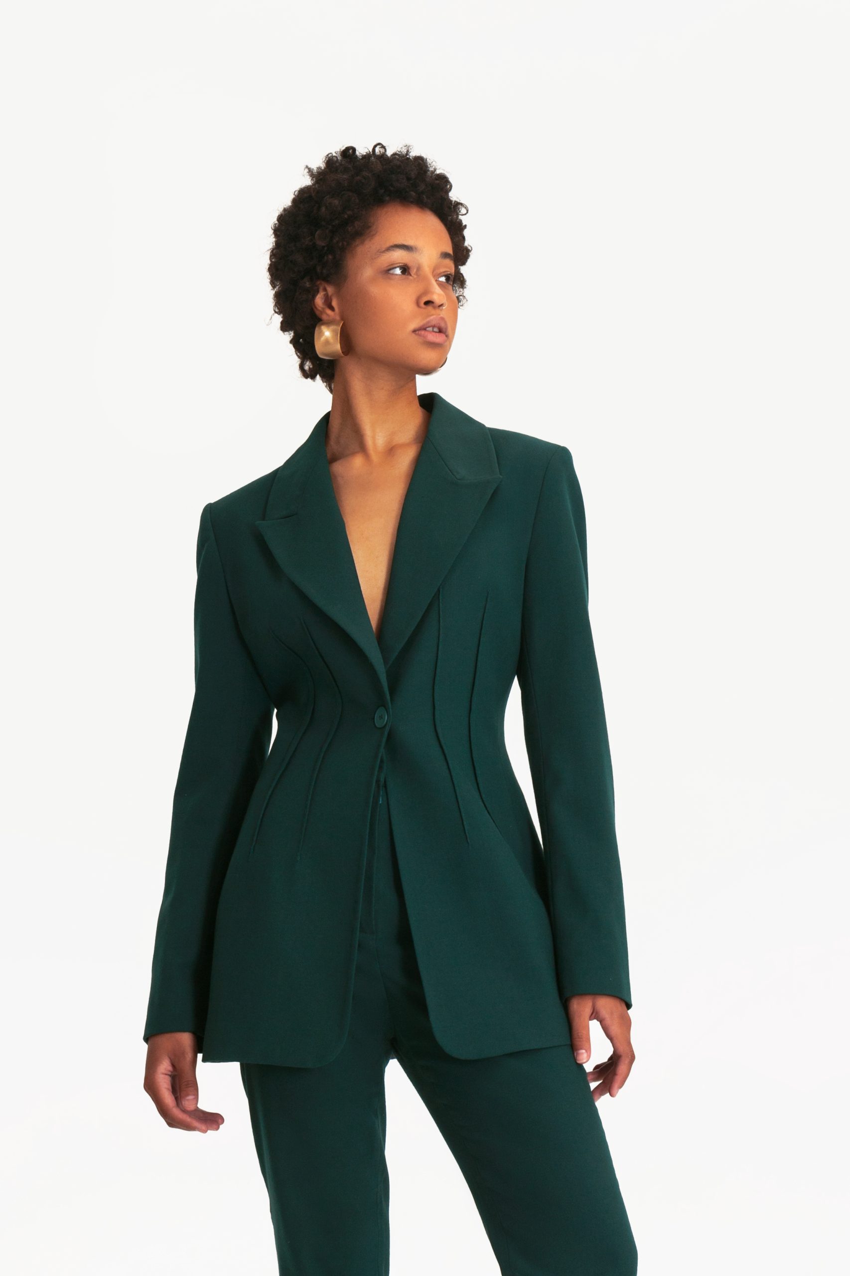 Woman wearing the Eteri Blazer sewing pattern from Vikisews on The Fold Line. A jacket pattern made in wool suiting, gabardine, jacquard, medium weight denim or corduroy fabrics, featuring a semi-fit, accentuated waist, back shoulder darts, bust darts, wa