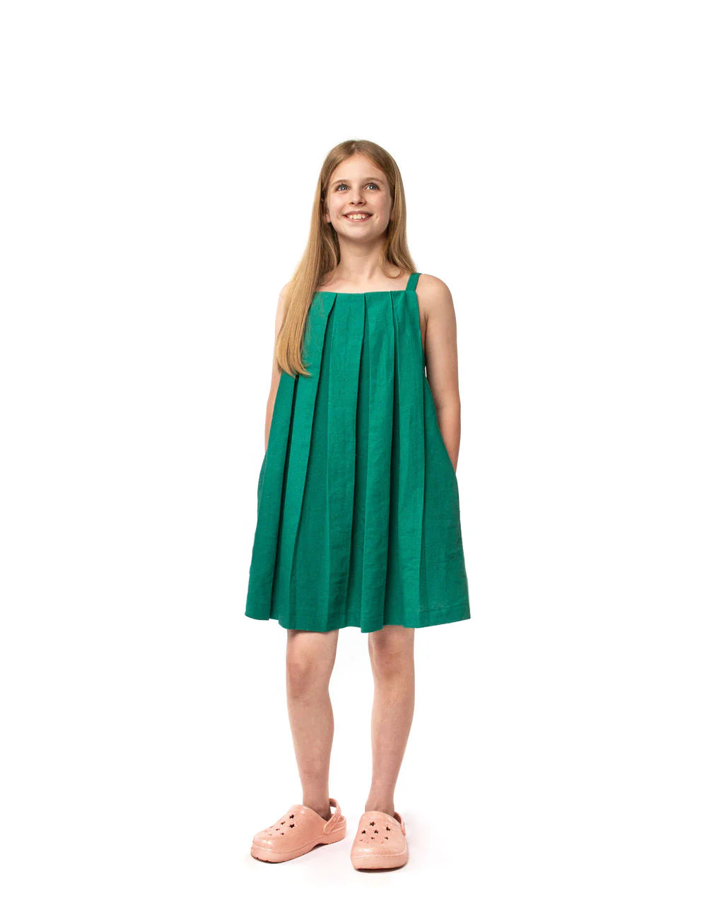 Girl wearing the Child/Teen Ettle Dress sewing pattern from Little Rosy Cheeks on The Fold Line. A trapeze dress with a pleated front and adjustable straps.