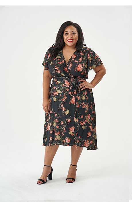Woman wearing the Eve Dress sewing pattern from Sew over It on The Fold Line. A wrap dress pattern made in viscose, crepe, georgette, lightweight cottons such as lawn or voile fabrics, featuring a V-neck, short sleeves, below knee length finish with dippe