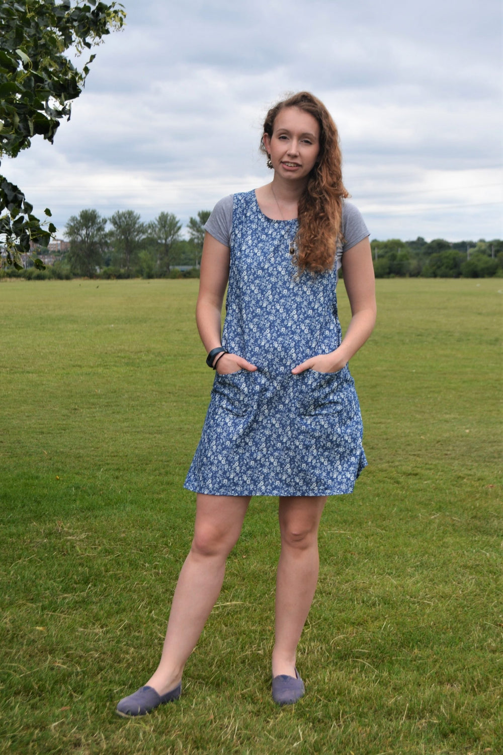 Woman wearing the Everyday Pinafore sewing pattern from Stitched in Wonderland on The Fold Line. A pinafore dress pattern made in cotton poplin, denim, corduroy, linen or wool fabrics, featuring patch pockets, mini length hem, relaxed fit, A-line shape an