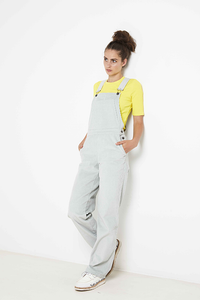 Woman wearing the Constance Overalls sewing pattern from Fibre Mood on The Fold Line. A dungaree pattern made in cotton corduroy, denim or thicker wool fabrics, featuring adjustable shoulder straps, side button closure, side pockets, large breast pocket a