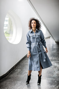 Woman wearing the Ivory Dress sewing pattern from Fibre Mood on The Fold Line. A shirtdress pattern made in denim, suede, soft leather, viscose, crepe, rayon, satin or (faux) silk fabrics, featuring a front snap/button closure, collar and stand, long gath