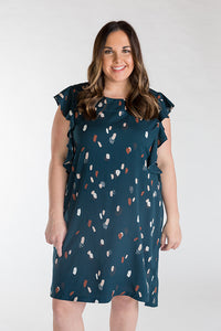 Woman wearing the Farrah Dress sewing pattern from Chalk and Notch on The Fold Line. A knee length dress pattern made in rayon challis, rayon crepe, rayon voile, cotton lawn, cotton voile, cotton shirting, linen or double gauze fabrics, featuring a round 