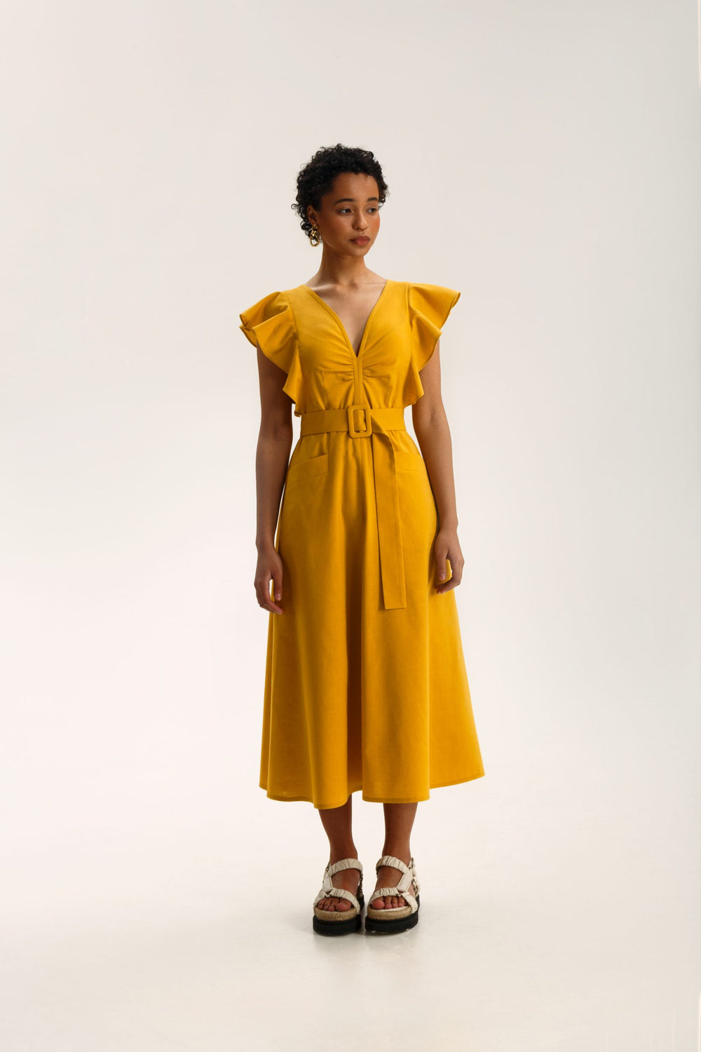 Woman wearing the Felicia Dress sewing pattern from Vikisews on The Fold Line. A dress pattern made in viscose, crepe, linen, poplin, satin, silk, cotton eyelet fabric or dress-weight denim fabrics, featuring a close-fit, accentuated waist, waist seam, de