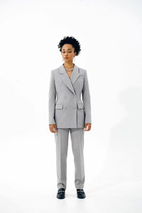 Woman wearing the Fernanda Blazer sewing pattern from Vikisews on The Fold Line. A blazer pattern made in wool suiting or gabardine fabrics, featuring a semi-fit, lined, accentuated waist, shoulder and waist darts, vertical bust darts, welt pockets, long 