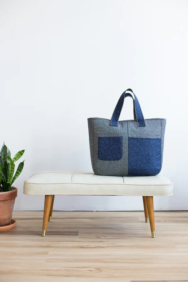 Photo showing the Fika Tote sewing pattern from Noodlehead on The Fold Line. A tote pattern made in canvas or medium weight quilting cotton fabrics, featuring a medium size, two front pockets, back lapped zipper pocket, recessed zipper closure and 2 carry