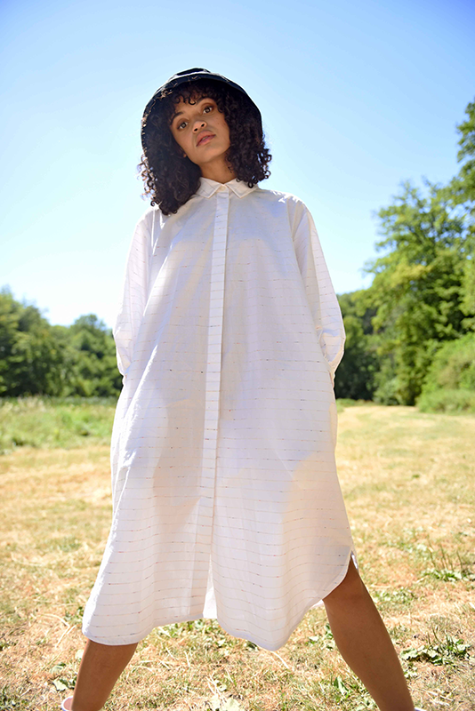 Woman wearing the Filippa Dress sewing pattern from Fibre Mood on The Fold Line. A shirtdress pattern made in cotton or linen fabrics, featuring voluminous bishop sleeves, collar, stand, front button closure, ¾ length sleeves with buttoned cuffs, relaxed 