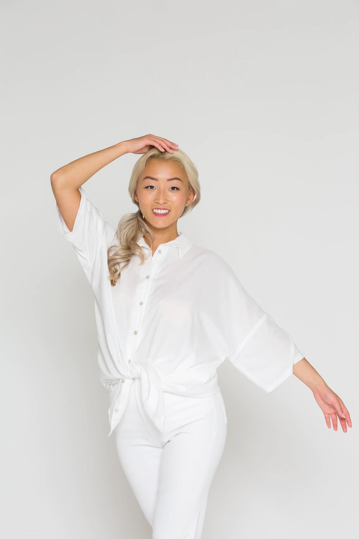 Woman wearing the Finja Blouse sewing pattern from Bara Studio on The Fold Line. A blouse pattern made in viscose, cotton linen or tencel fabrics, featuring an oversized fit, classic shirt collar, button placket, high-low curved hem line and dropped sleev