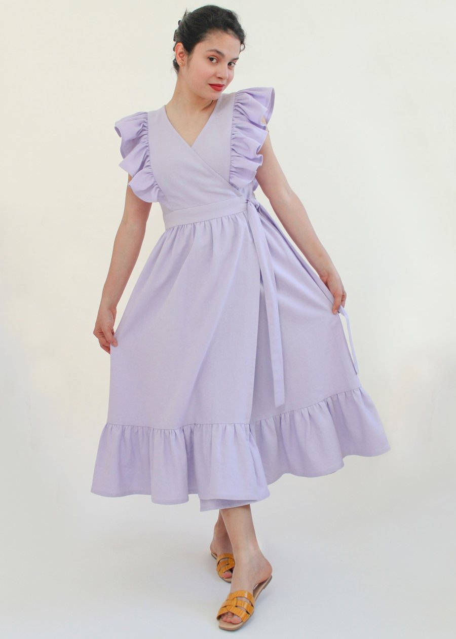 Woman wearing the Flor Dress and Top sewing pattern from Bella Loves Patterns on The Fold Line. A wrap dress pattern made in cotton linen blends, cotton lawns, poplin, voile, broderie anglaise or shirting fabrics, featuring shoulder ruffles, princess seam
