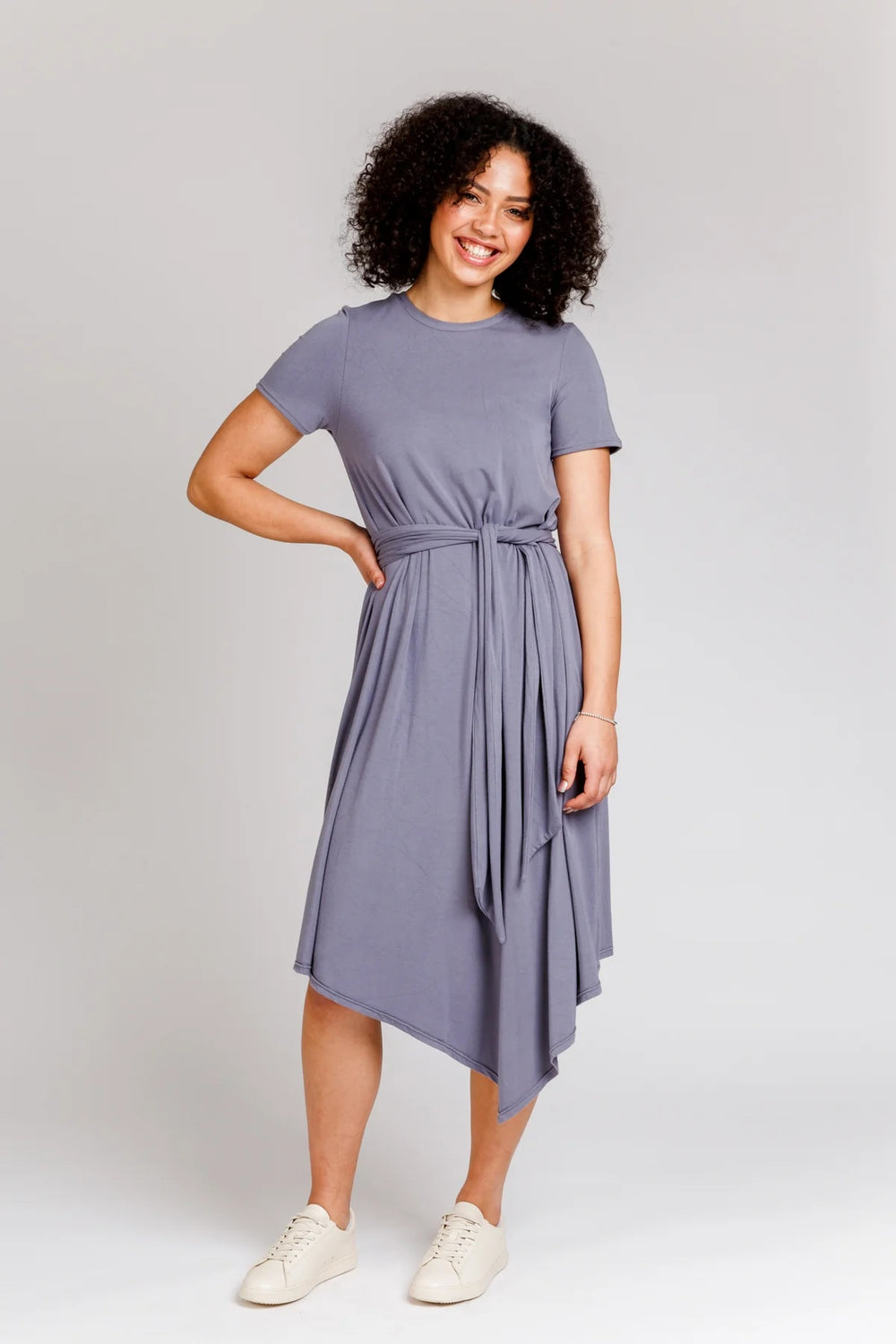 Woman wearing the Floreat Dress and Top sewing pattern from Megan Nielsen on The Fold Line. A dress pattern made in cotton, linen, chambray, rayon, or silk fabrics, featuring an asymmetrical hem, in-seam pockets, short sleeves, round neck, invisible back 