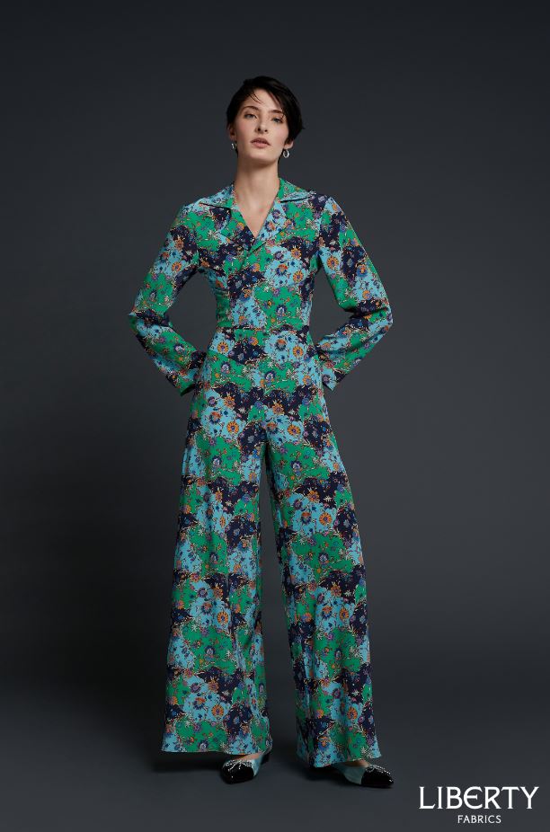 Woman wearing the Florence Palazzo Suit sewing pattern by Liberty Sewing Patterns. A trouser and wrap blouse pattern made in cotton, silk, linen or light velvet fabrics, featuring wide legged trousers that are loose fitting through the hips, wide front an