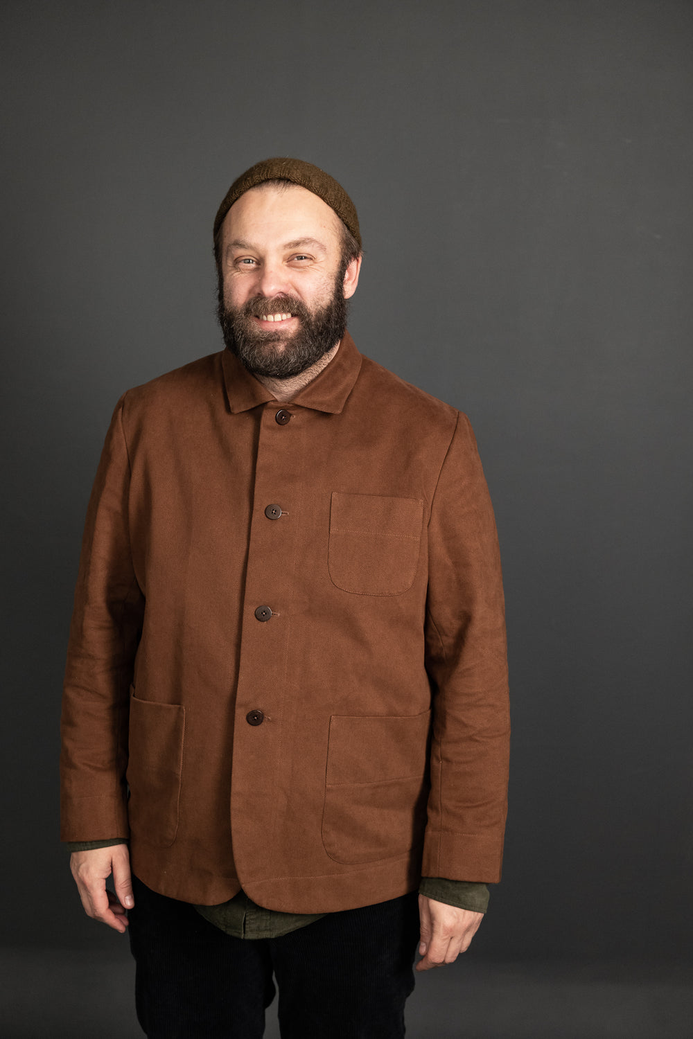 Man wearing the Men's Foreman Jacket sewing pattern from Merchant and Mills on The Fold Line. A jacket pattern made in oilskin, cotton canvas, twill, denim, linen corduroy or woollen tweed fabrics, featuring a boxy cut, two piece sleeves, square collar, b