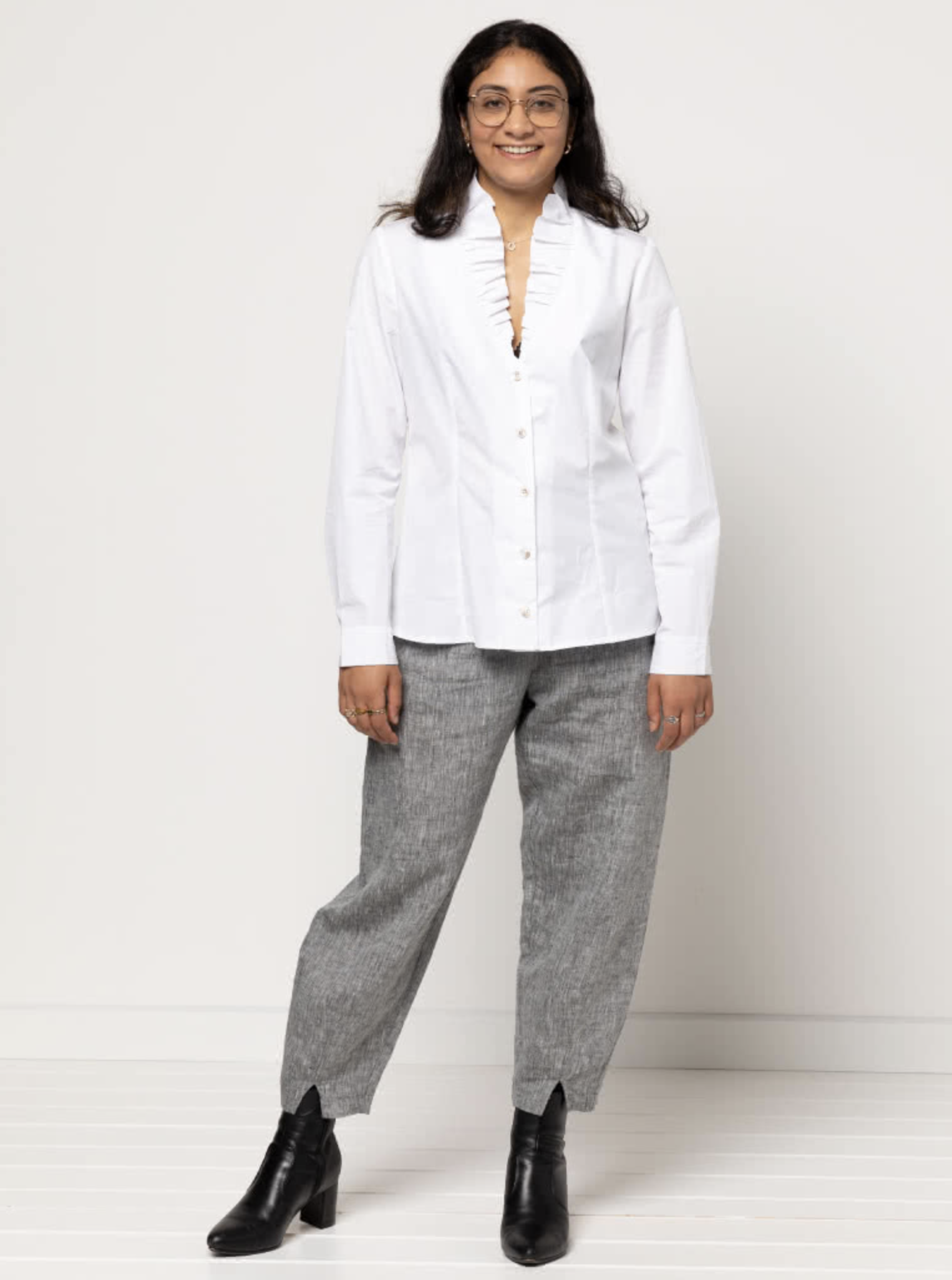 Woman wearing the Francesca Woven Shirt sewing pattern from Style Arc on The Fold Line. A shirt pattern made in, rayon, silk, linen or cotton fabrics, featuring a button-front, ruffle neck, front and back darts, long sleeves with tucks and cuffs.