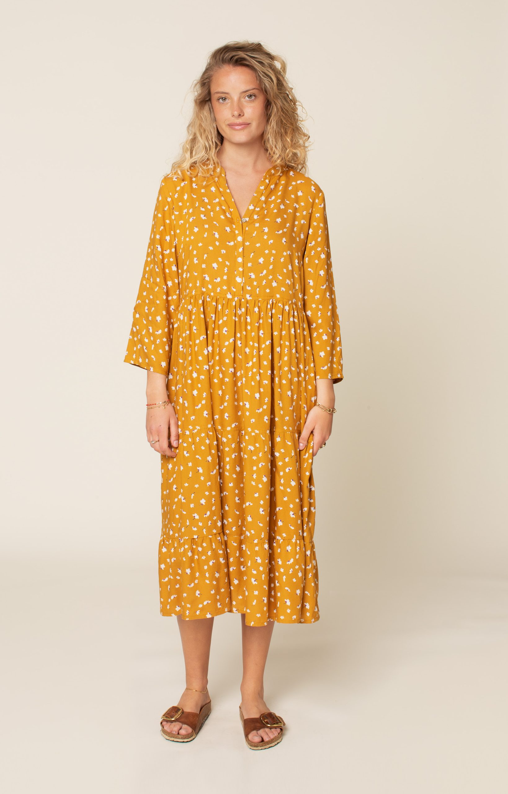 Woman wearing the Freedom Dress sewing pattern from Wardrobe by Me on The Fold Line. A dress pattern made in cotton, viscose, tencel or silk fabrics, featuring a loose, floaty style, in-seam pockets, gathered skirt with tiered hem, ¾ length loose fitting 