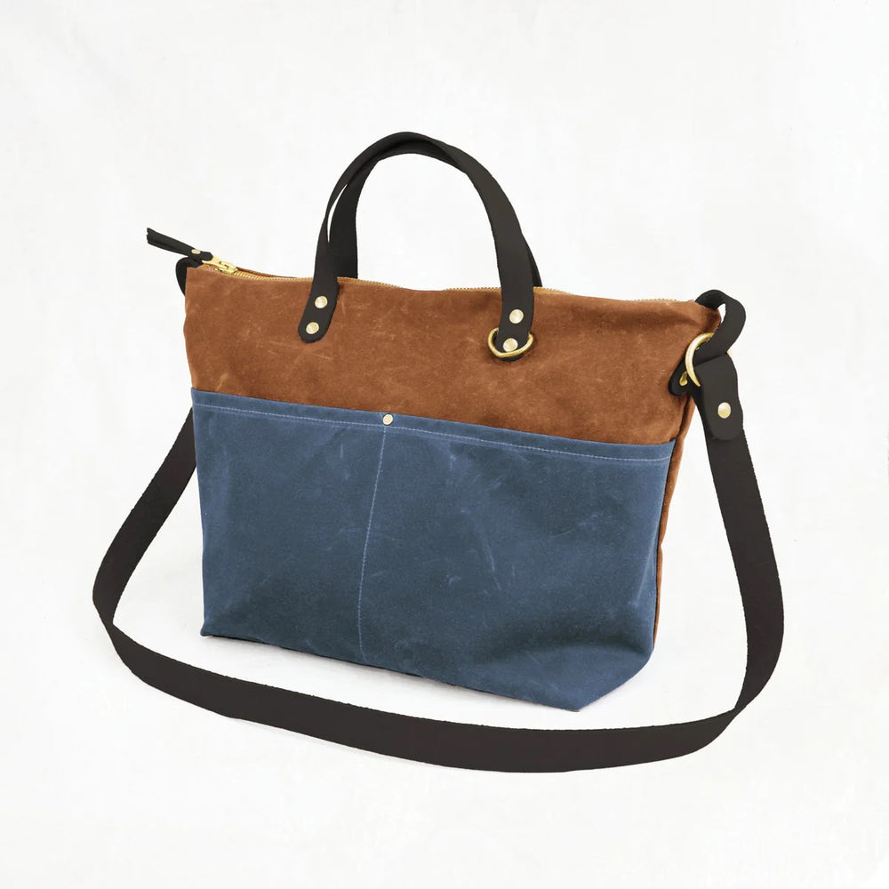 Photo showing the Fremont Tote Bag sewing pattern from Klum House on The Fold Line. A tote pattern made in canvas, waxed canvas, or denim fabrics, featuring a zip top closure, interior and exterior pockets, canvas lining, leather handles and cross body st