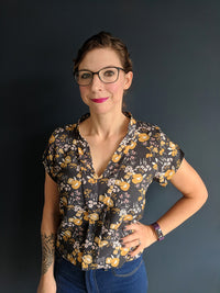 Woman wearing the Evelyn Blouse sewing pattern by Experimental Space. A blouse pattern made in rayon or crepe fabrics, featuring a V-neckline and short set-in sleeves with slit openings at the cuffs.