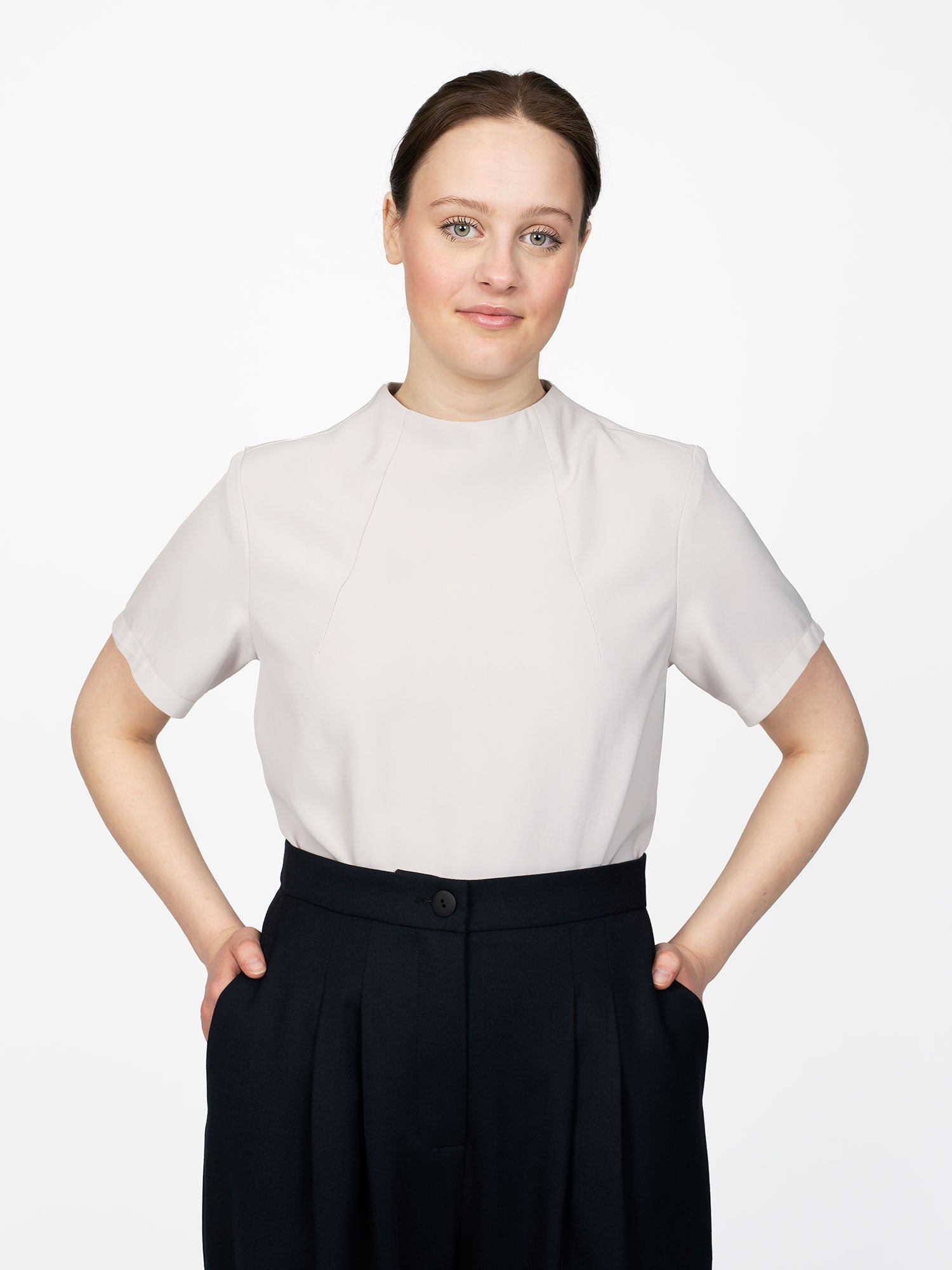 Woman wearing the Funnel Neck Top sewing pattern from The Assembly Line on The Fold Line. A top pattern made in cotton, silk, lawn, linen, crepe de chine or wool crepe fabrics, featuring elbow-length sleeves, raised neckline with front neck darts and back