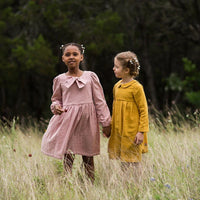 Children wearing the Baby/Child Geranium Expansion Pack sewing pattern from Made by Rae on The Fold Line. A dress pattern made in cotton fabrics, featuring a high or standard waist with gathers, back button opening, round neck with bow or Peter Pan collar