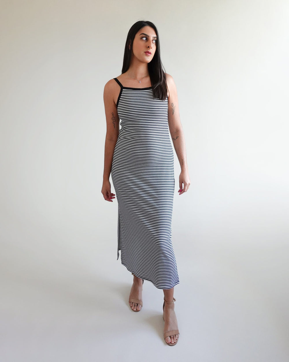 Woman wearing the Gia Dress sewing pattern from Tammy Handmade on The Fold Line. A midi dress pattern made in stretch knit fabric, featuring a figure-hugging silhouette, slightly curved neckline and armholes finished with binding, shelf bra for added supp