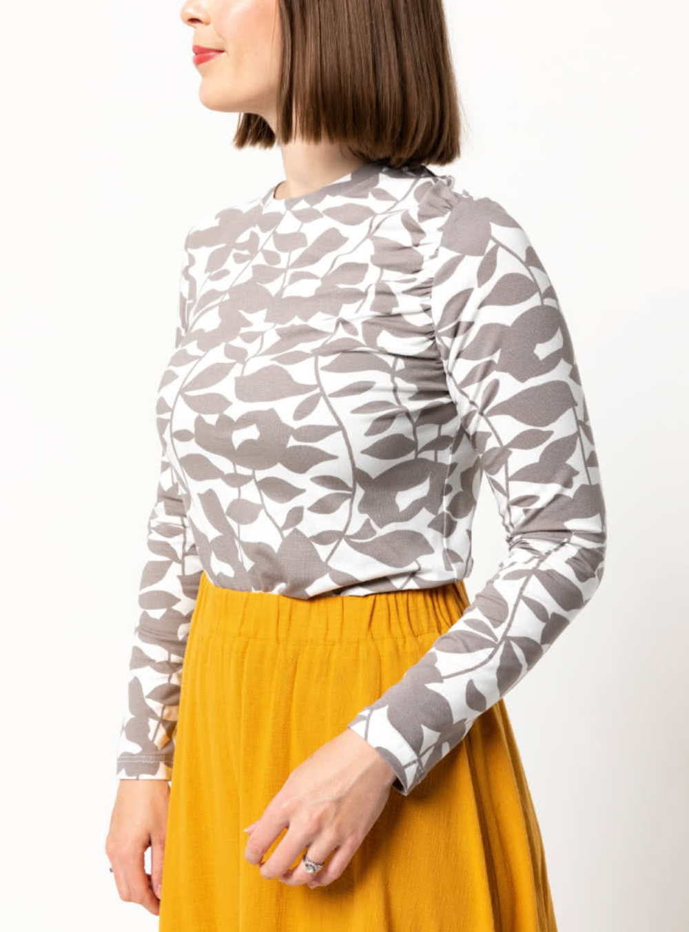 Woman wearing the Glenda Knit Top sewing pattern from Style Arc on The Fold Line. A top pattern made in knit, jersey, or T-shirt fabrics, featuring long sleeves, round neck, gathered left armhole and semi fitted.