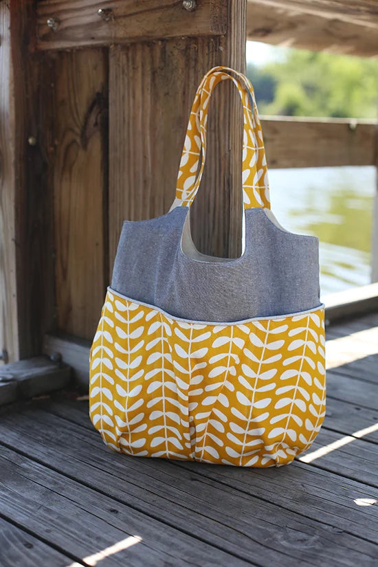 Photo showing the Go Anywhere Bag sewing pattern from Noodlehead on The Fold Line. A bag pattern made in heavy linen, denim, canvas or twill fabrics, featuring a roomy size, three easily accessible front pockets, one large back pocket, double handle and a