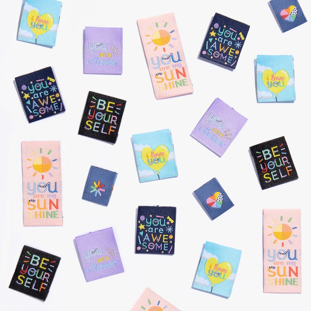 Photo showing ‘Going Places’ Woven Labels from Kylie & The Machine on The Fold Line. A washable, durable and non-scratchy fabric label featuring various sayings: You Are My Sunshine, You Are Clever, Be Yourself, I Love You a Heart and Asterisk, they are a