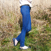 Child wearing the Child/Teen Gotan Jeggings sewing pattern from Petits D'om on The Fold Line. A jeggings pattern made in stretch denim, stretch cotton, or stretch velvet fabrics, featuring a skinny fit, back patch pockets, front slash pockets, elasticated