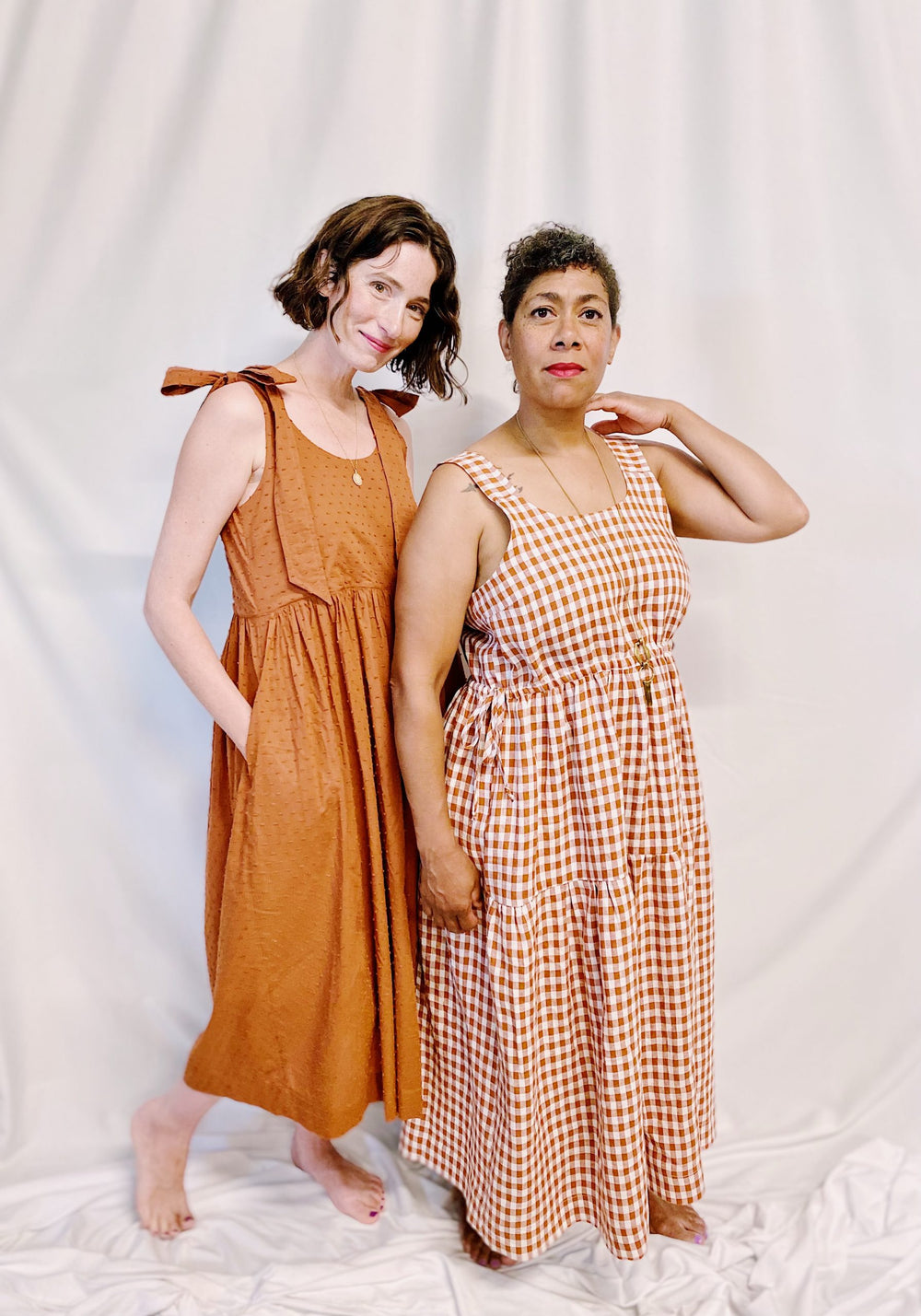 Women wearing the Grace Dress sewing pattern from Marsha Style on The Fold Line. A sundress pattern made in cotton lawn, voile, batiste, poplin, lightweight linen or viscose fabrics, featuring long shoulder ties or straps, bust darts, gathered skirt with 