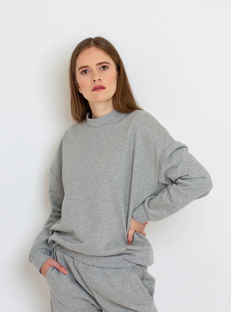 Woman wearing the Hanna Sweater sewing pattern from Bara Studio on The Fold Line. A sweater pattern made in medium-weight stretch fabrics such as sweat or French terry fabrics, featuring an oversized silhouette, dropped shoulders, ribbed neckline, hem and