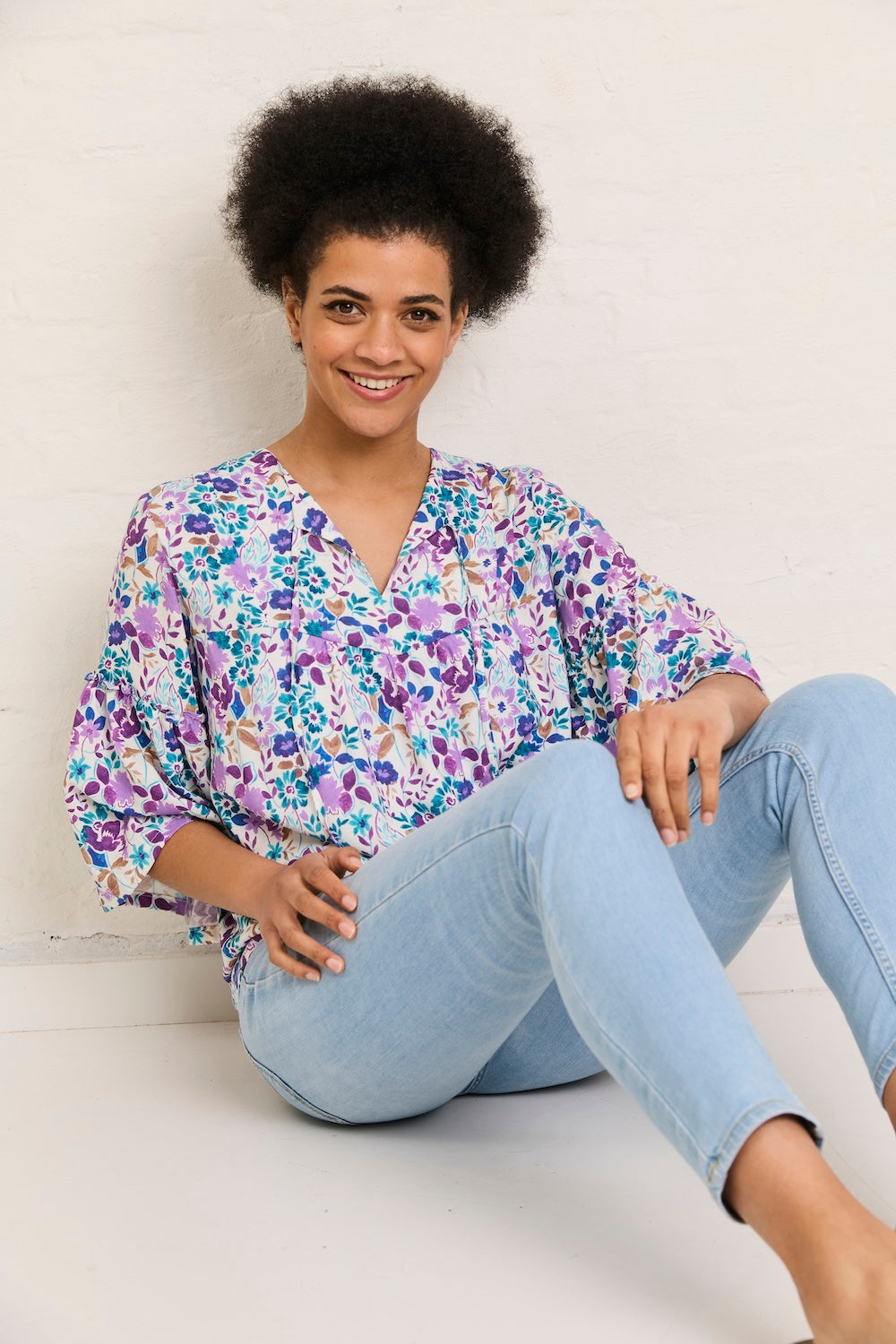 Woman wearing the Hannah Blouse sewing pattern from Atelier Jupe on The Fold Line. A blouse pattern made in viscose, cotton, tencel, linen, or double gauze fabric, featuring a relaxed fit, gathered bodice, wide gathered sleeves, and ties at the neckline.