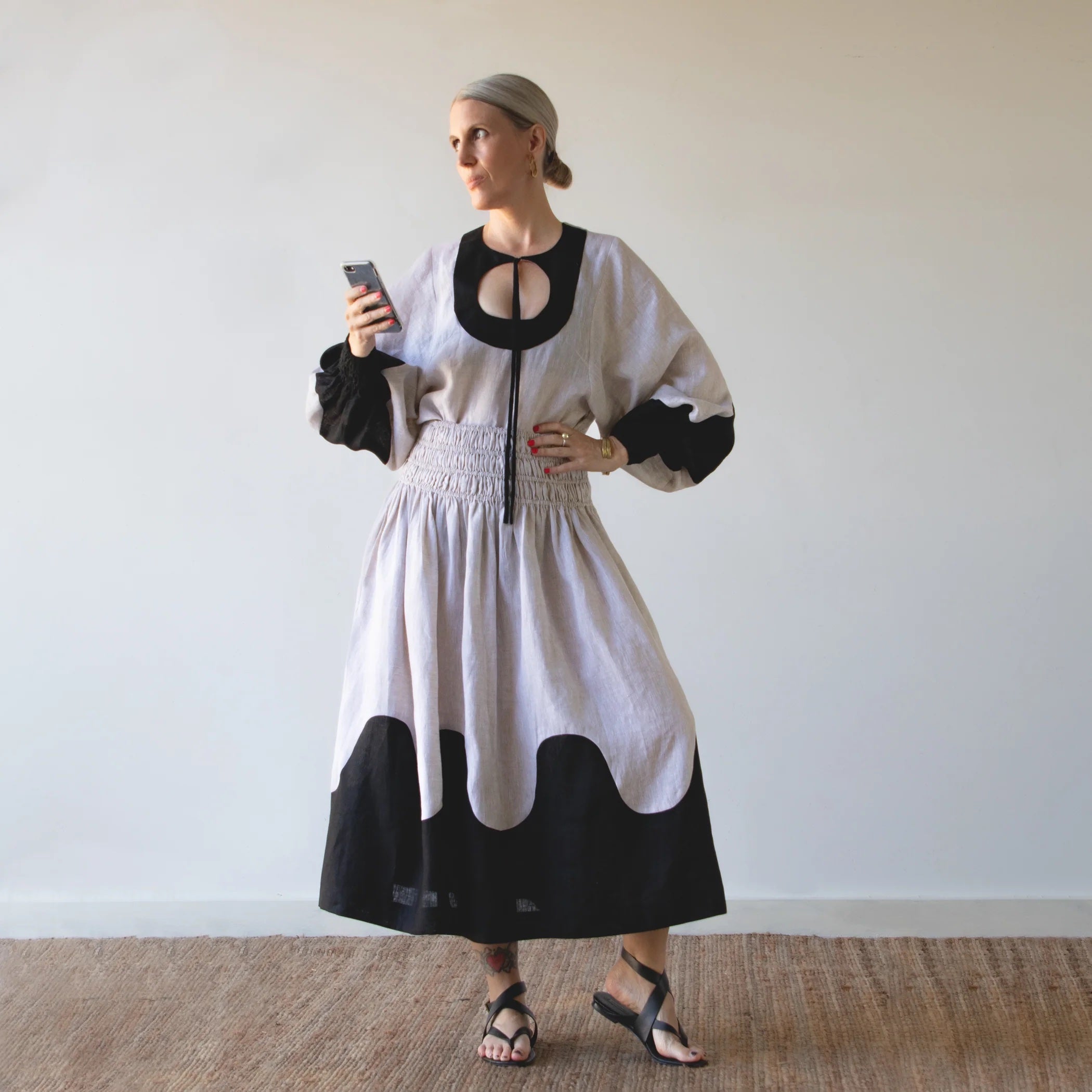 Woman wearing the Harmonic Set sewing pattern from Pattern Fantastique on The Fold Line. A top and skirt pattern made in linen or cotton fabrics, featuring a top with circular keyhole neckline with tie, balloon sleeve with deep armhole and faux-shirred cu