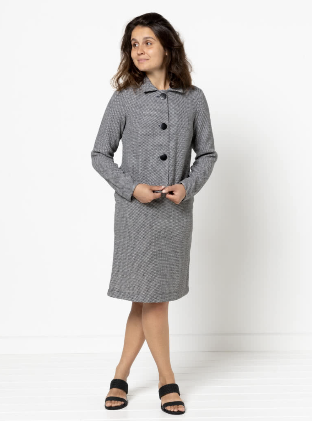 Woman wearing the Harriet Jacket sewing pattern from Style Arc on The Fold Line. A lined or unlined jacket pattern made in fine wool, silk brocade, or linen fabric, featuring a boxy silhouette, collar, button front, bust darts, and darted one piece sleeve