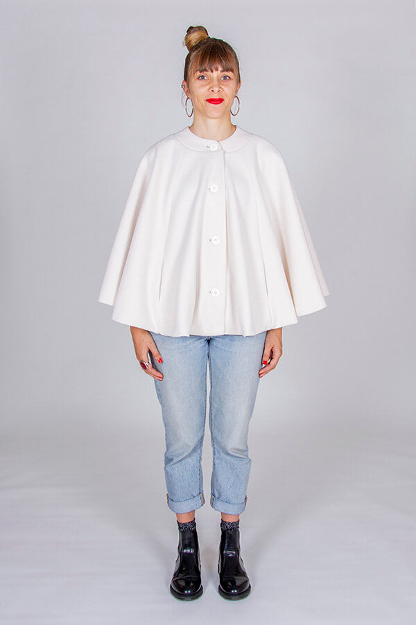 Woman wearing the Harry Cape sewing pattern from I AM Patterns on The Fold Line. A cape pattern made in boiled wool, wool gabardine, melton, bouclé or jacquard. fabrics, featuring a circular silhouette, in-seam pockets, flat collar, fully lined, front but