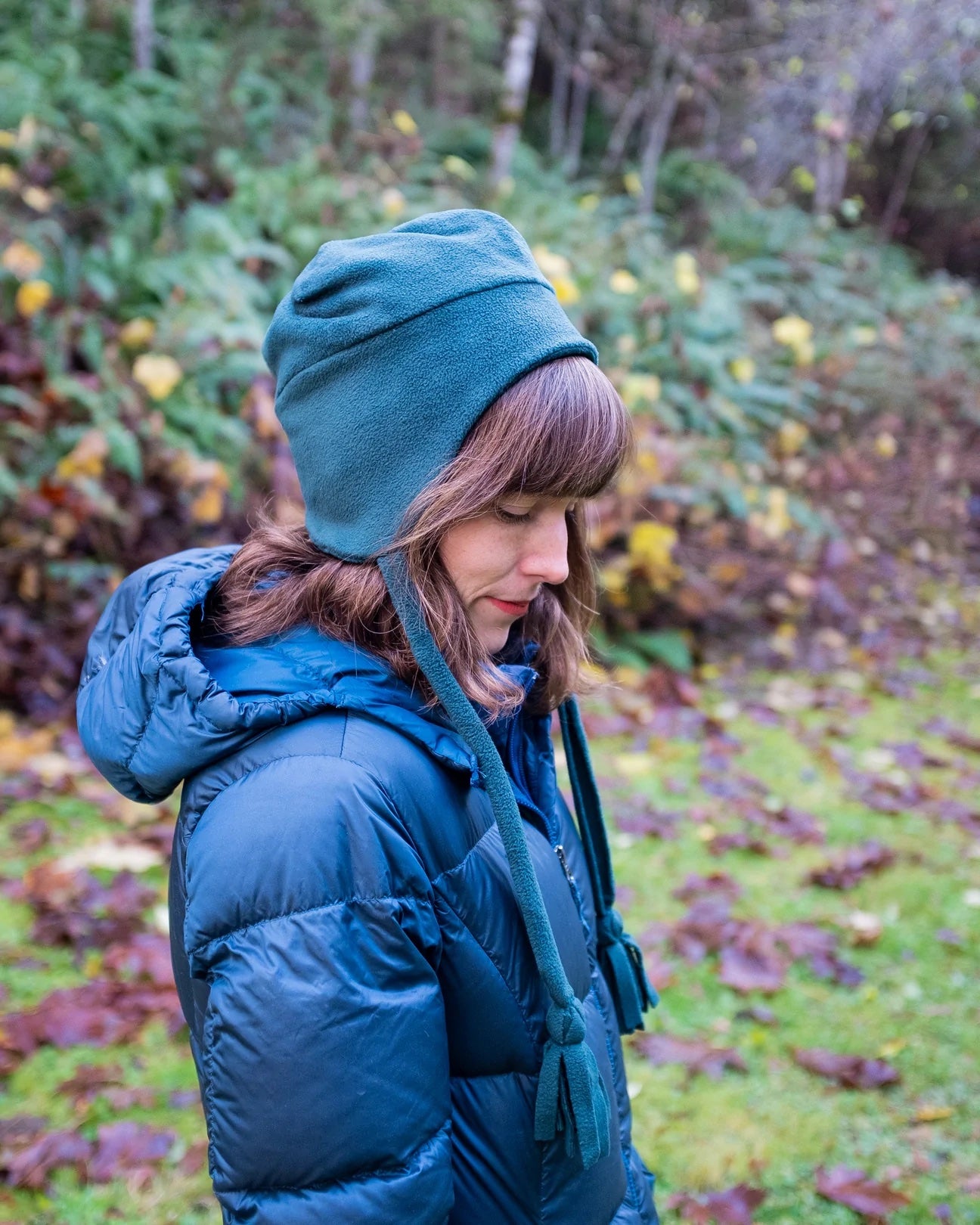 Woman wearing the Haslam Hat sewing pattern from Thread Theory on The Fold Line. A beanie pattern made in sweatshirt fleece, lofty French terry or flannel fabrics, featuring a square-topped design, ear flaps and tassel ended ties.