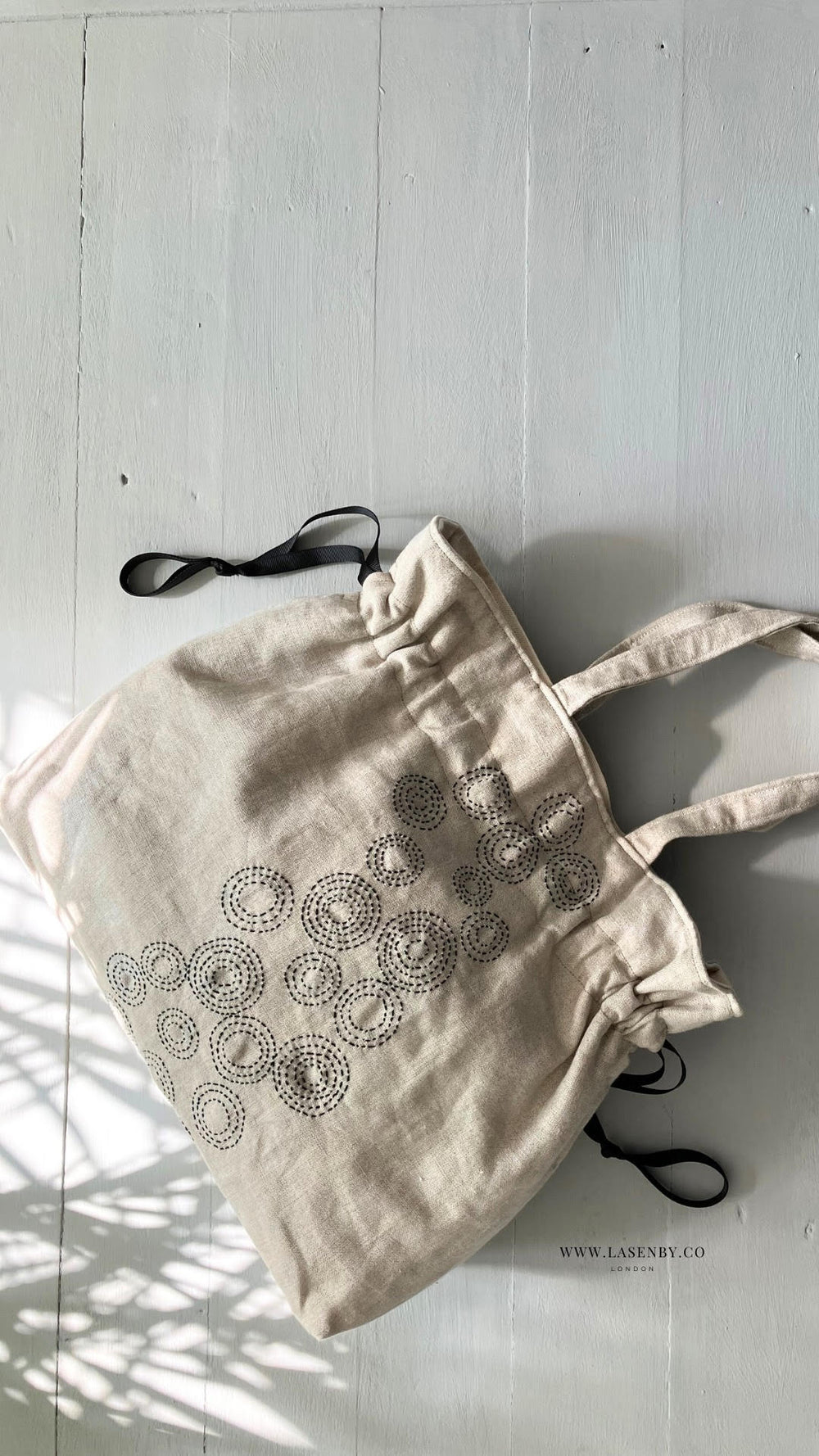 Photo showing the Hebe Maru Bag sewing pattern from Lasenby on The Fold Line. A drawstring tote pattern made in linen, lightweight canvas, quilting cotton, twill, duck, lightweight denim, or fine tweed fabrics, featuring a sashiko embroidery design, two s
