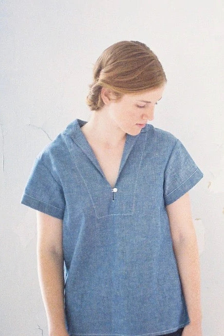 Woman wearing the Heidi Pullover Top sewing pattern from Anna Allen on The Fold Line. A top pattern made in light to medium weight woven fabrics, featuring side slits, no bust darts, short sleeves, back yoke with gathers, straight collar and front slit th