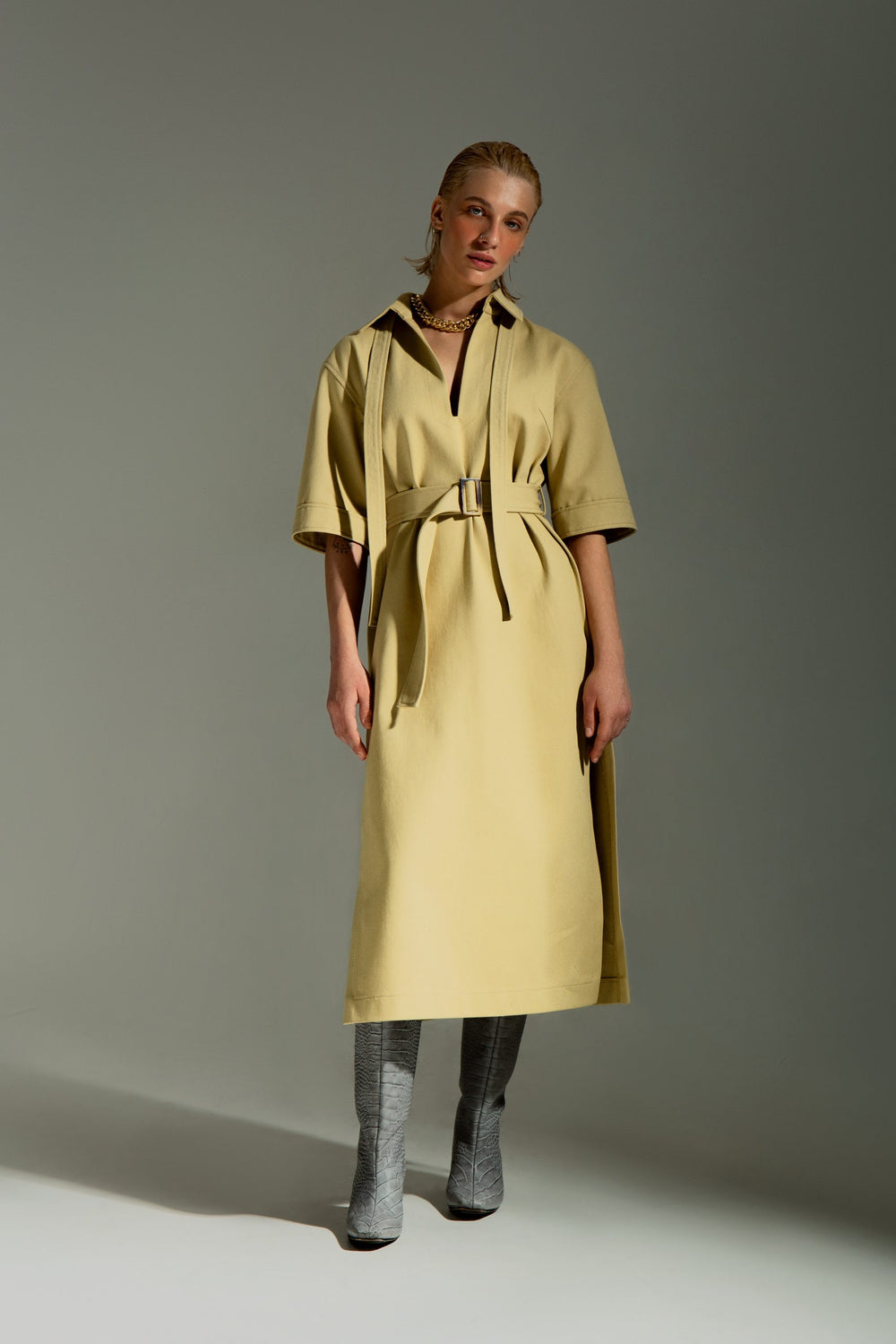 Woman wearing the Helen Dress sewing pattern from Vikisews on The Fold Line. A dress pattern made in wool, gabardine, denim, fine wale corduroy, corduroy, faux leather or suede fabrics, featuring a relaxed fit with straight silhouette, detachable belt wit