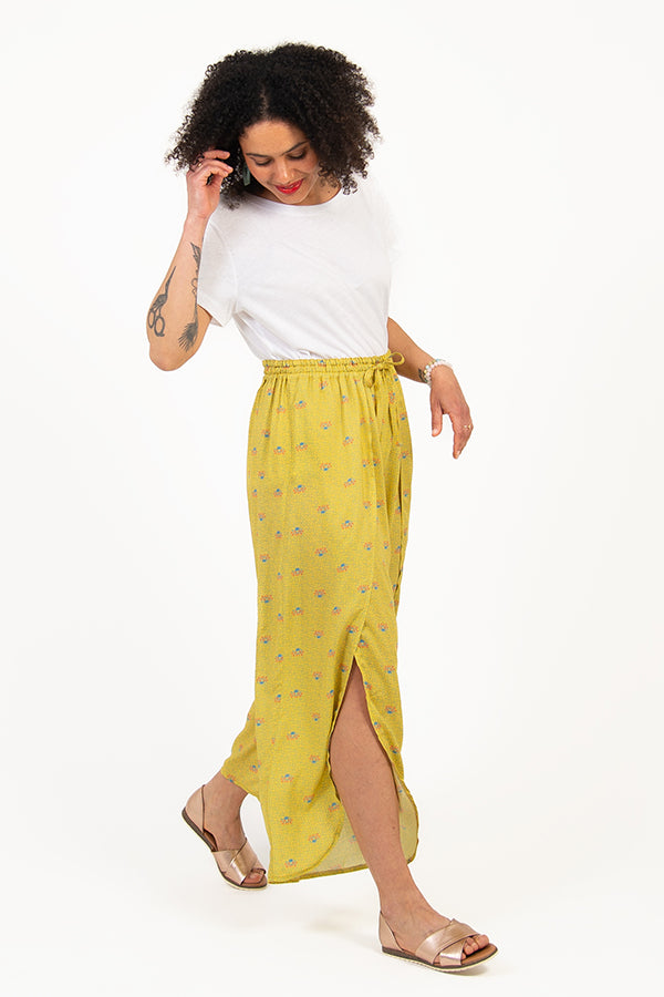 Woman wearing the Hélios Trousers sewing pattern from I AM Patterns on The Fold Line. A trouser pattern made in rayon, silk, lyocell, cupro, cotton crêpe or viscose crêpe fabrics, featuring an elasticated waistband with drawstring, full length front openi