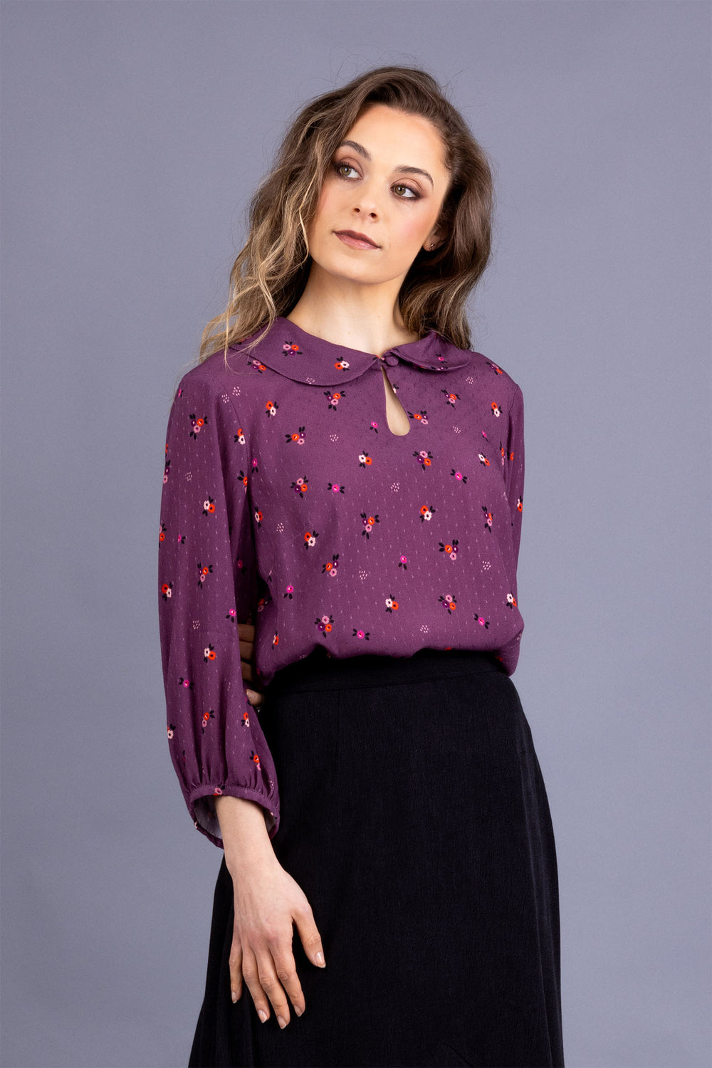 Woman wearing the Helmi Blouse sewing pattern from Forget-me-not Patterns on The Fold Line. A blouse pattern made in dotted swiss, cotton crepe, double gauze, viscose, silk crepe, or linen fabrics, featuring a semi-fitted, pull-on style, front neck button