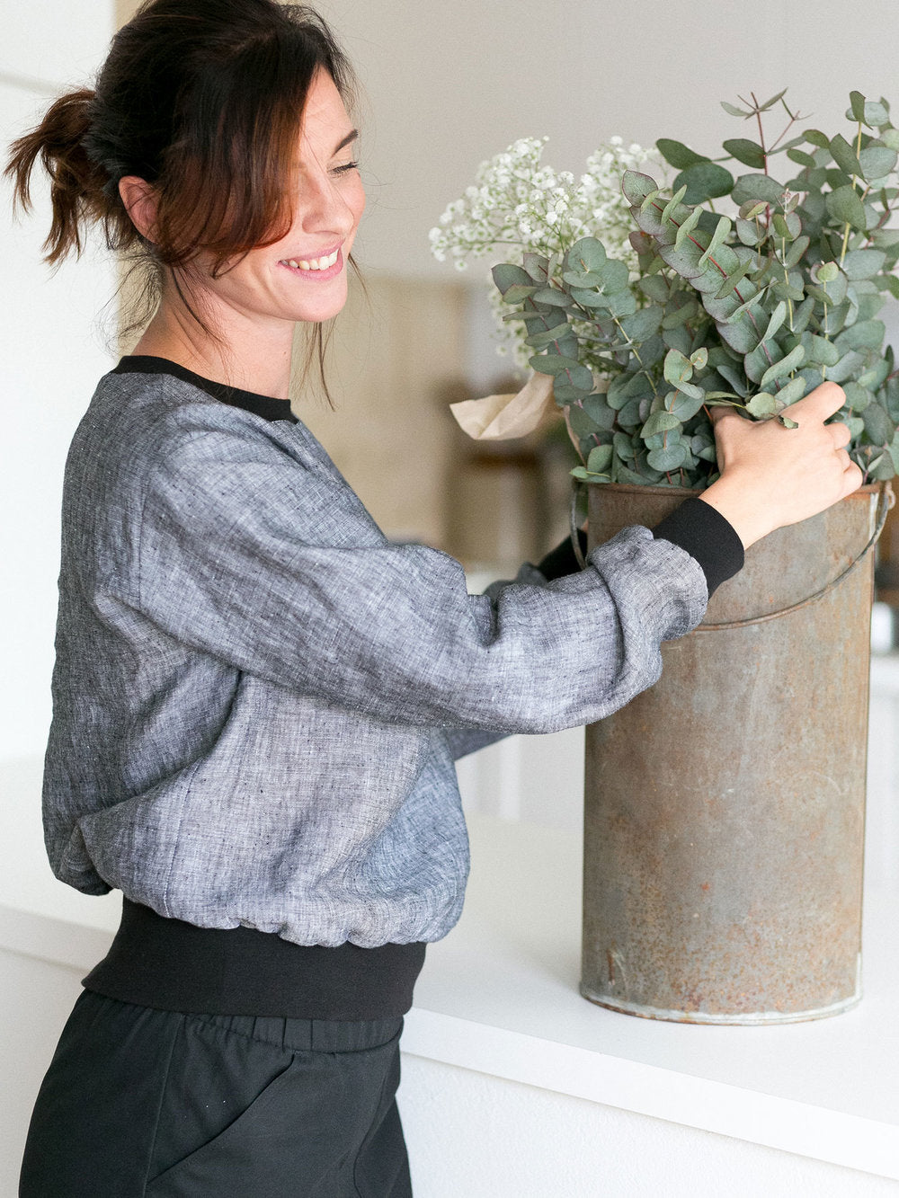 Woman wearing the High Cuff Sweater sewing pattern by The Assembly Line. A traditional sweatshirt pattern made in denim, cotton twill or canvas featuring rib cuffs at the neck, sleeves and bottom.